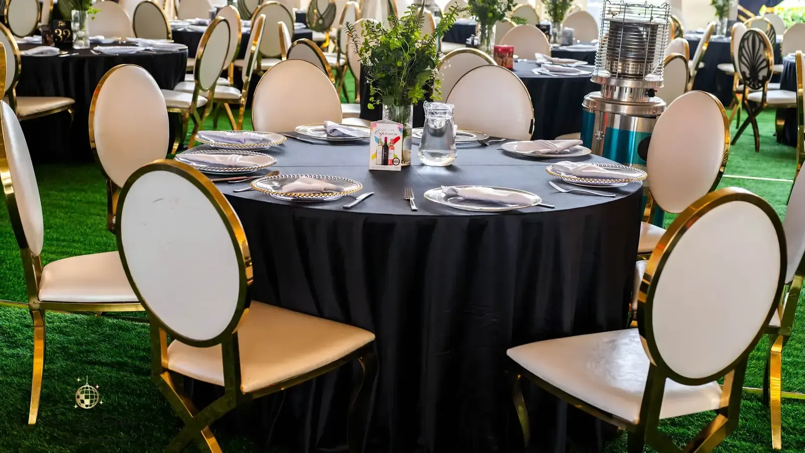 Corporate round table setup with gold chairs and black linen