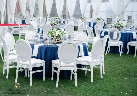 Another angle of the tent interior showing the layout of round tables with navy blue linens and